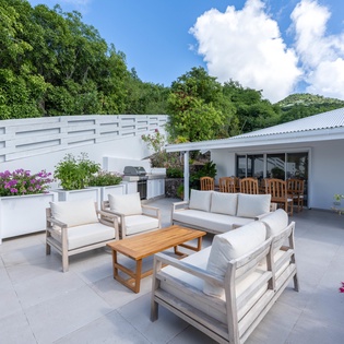 Spacious covered terrace with comfortable seating and tropical mountain views creating the perfect outdoor retreat.