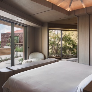 Drift into peaceful sleep in your elegant bedroom, where floor-to-ceiling windows frame stunning sea views and tropical gardens.