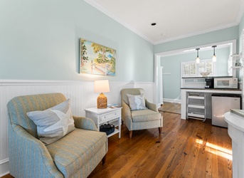 Sink into plush coastal-style seating in your bright, airy retreat with warm wood floors and calming sea-blue walls. Your kitchenette awaits just steps away for easy in-room dining.