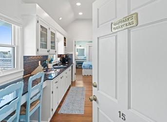 Step into your bright coastal kitchen, complete with granite counters, white cabinets, and charming touches that invite you to brew morning coffee while sunshine streams through the windows.