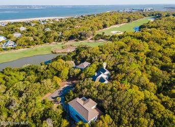 Stunning aerial view showcasing the property's prime location nestled between lush forest and championship golf course, just moments from pristine beaches.