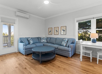 Sink into your stylish living area with warm wood floors and treetop views through picture windows. A sectional sofa invites leisurely evenings while air conditioning keeps things comfortable.