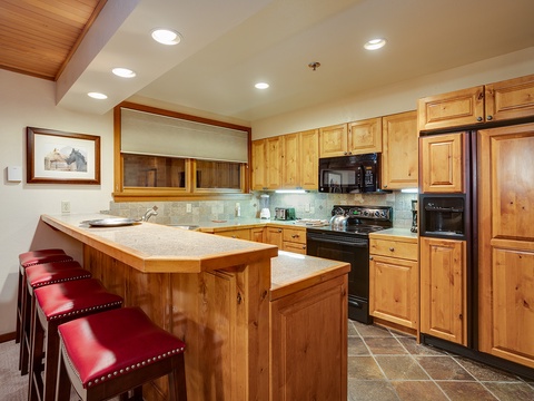 Step into your fully equipped kitchen with warm wood cabinetry, granite counters, and stainless appliances. Gather at the breakfast bar for morning coffee or evening wine after a day of adventure.