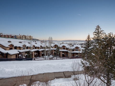Snow-covered property nestled in a serene mountain setting, with clear winter skies and distant peaks framing this peaceful retreat.