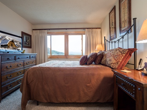 Wake up to mountain views from your cozy bed, where rich textured linens meet classic furnishings. Gentle natural light and warm lamps create your perfect mountain retreat.