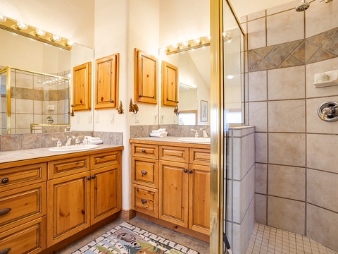 Relax in your private sanctuary with dual vanities, elegant cabinetry, and a spacious walk-in shower adorned with beautiful tile work—designed for your comfort and convenience.