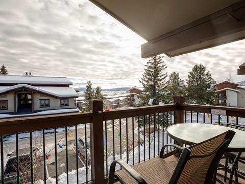 Sip your morning coffee on this private balcony overlooking snow-dusted rooftops and mountain views. Comfortable seating invites you to unwind while taking in the peaceful alpine surroundings.