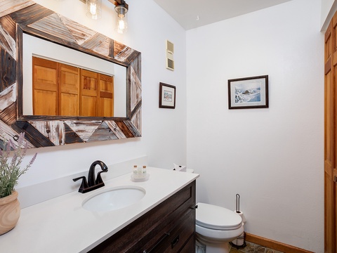 Step into your private bathroom featuring rustic wood accents, a clean vanity, and thoughtful touches like fresh toiletries awaiting your arrival.