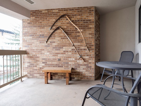 Relax on your private balcony with a charming brick accent wall and cozy seating, perfect for morning coffee or evening unwinding while overlooking the peaceful surroundings.