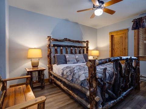 Step into your cozy mountain retreat featuring a handcrafted log bed, soft bedside lighting, and a ceiling fan to keep you comfortable year-round.