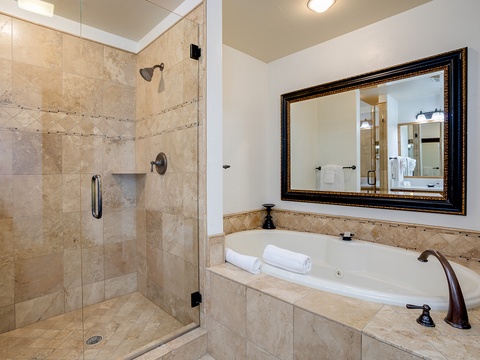 Unwind in your spa-like bathroom featuring a spacious walk-in shower and deep soaking tub. Elegant travertine tile and thoughtful touches create a serene retreat after a day of adventure.