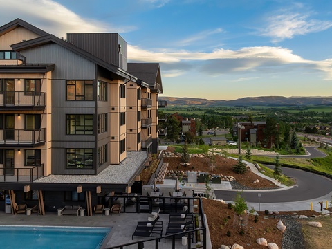 Modern mountain retreat set against rolling hills and open valleys, offering a peaceful escape with outdoor pool and spacious grounds for relaxation.