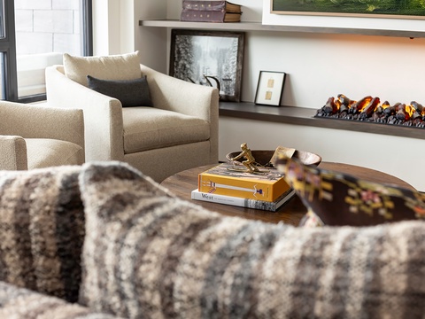 Curl up with your favorite book by the glowing fireplace, nestled into plush seating that invites you to linger and unwind in this thoughtfully designed living room.