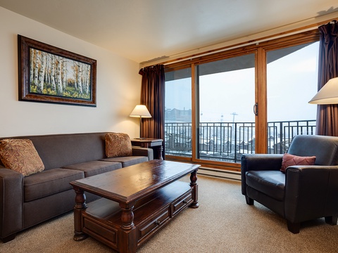 Settle into your cozy living room where mountain views frame every moment. Sink into plush seating, enjoy the warm lighting, and step out to your private balcony to breathe in fresh alpine air.