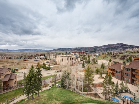 Aerial view of the property nestled in a scenic mountain valley, surrounded by natural landscape and neighboring developments.