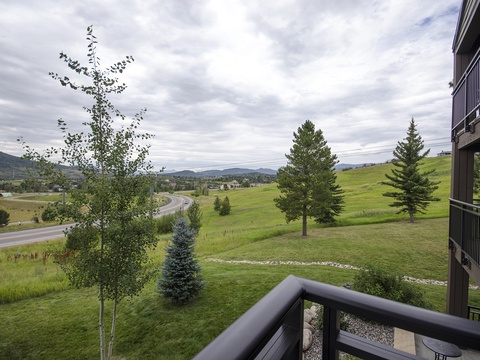Peaceful mountain valley views stretch across green hills and quiet roadways, framed by evergreen pines and open skies. A serene arrival to a naturally beautiful area.