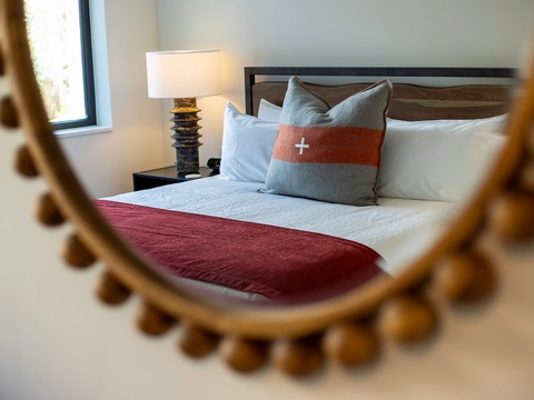Sink into plush pillows and soft linens in your restful bedroom, where natural light and thoughtfully curated touches create the perfect sanctuary for your getaway.