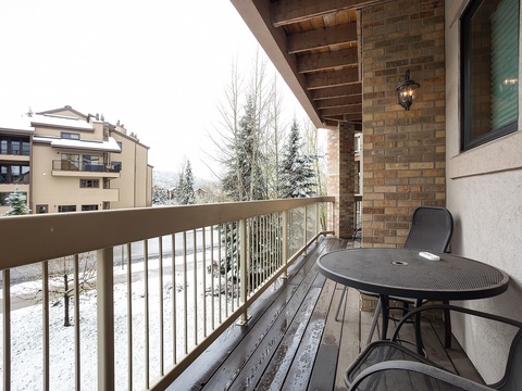 This private balcony offers serene winter views of the surrounding neighborhood, complete with cozy outdoor seating perfect for morning coffee or evening relaxation.