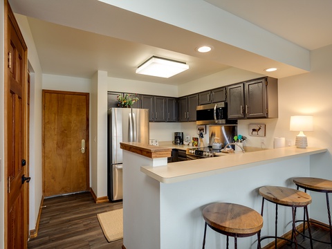 Your kitchen is ready for culinary adventures, featuring modern appliances, granite counters, and a breakfast bar where you can sip your morning coffee.
