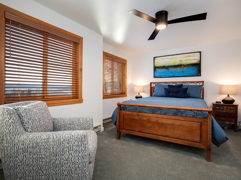 Unwind in your serene bedroom with warm wood tones, plush bedding, and artwork that sets a calming mood. Soft lamps flank the bed, while ceiling fan keeps you comfortable year-round.