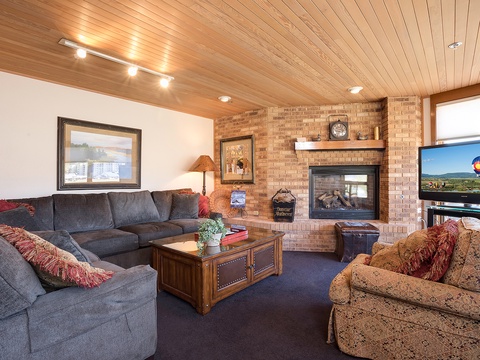 Sink into plush sofas and warm up by the brick fireplace in your inviting living room, where mountain views and ample space create your perfect gathering spot.