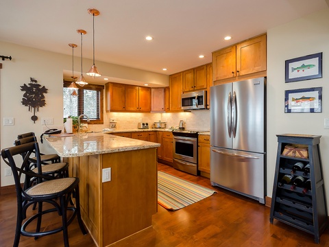 Your fully-equipped kitchen awaits with stainless steel appliances, granite counters, and a cozy breakfast bar—perfect for preparing home-cooked meals during your mountain getaway.