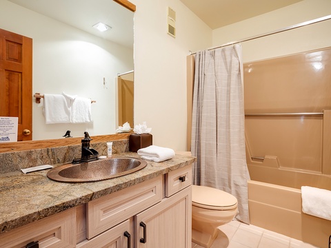 Your private bathroom features a copper sink, granite counters, fresh towels, and a tub-shower combo—everything you need to refresh after a day of adventure.