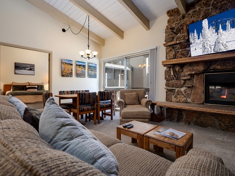 Curl up on plush sofas by the crackling stone fireplace, where rustic wood beams and cozy textures invite you to unwind after a day of mountain adventures.