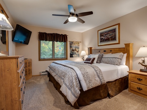 Sink into your cozy king bed under soft linens, surrounded by warm wood tones and homey touches. Your ceiling fan keeps the air fresh while you unwind.