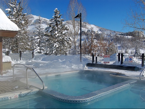 A heated outdoor hot tub offers scenic mountain and ski slope views, inviting you to relax in warm waters after a day on the slopes.
