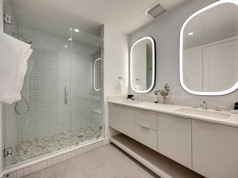 Step into a spa-like sanctuary with a spacious walk-in shower, dual illuminated mirrors, and elegant modern finishes that make your daily routine feel luxurious.