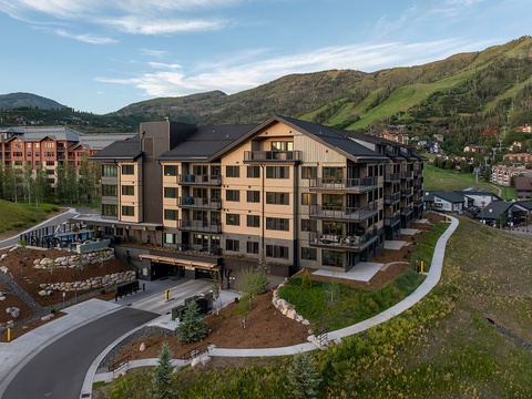 A welcoming mountain resort in a scenic valley setting, surrounded by rolling hills and neighboring properties at the base of the mountains.
