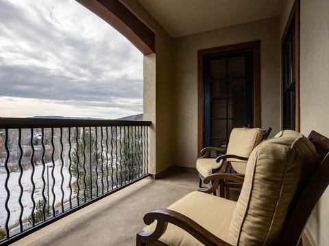 The private balcony offers a peaceful retreat with comfortable seating where you can unwind and soak in sweeping views of rolling hills and dramatic skies.