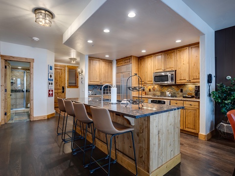 Your fully-equipped kitchen features warm wood cabinetry, granite countertops, and a spacious island with seating—perfect for preparing meals together and gathering with loved ones.