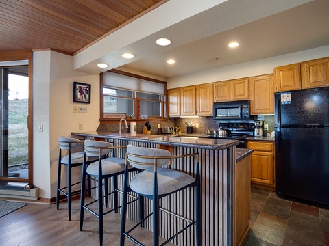 Gather around the island for morning coffee or casual meals in your fully equipped kitchen with warm wood accents and all the comforts of home.