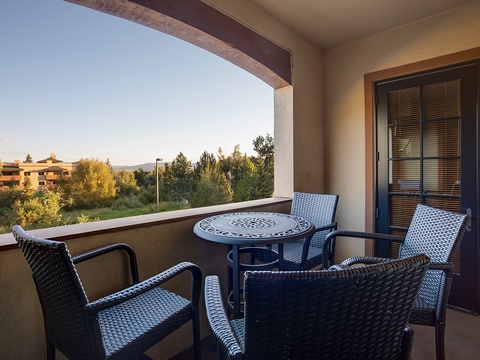 Your private balcony offers a peaceful retreat with comfortable seating, perfect for enjoying morning coffee or evening relaxation while taking in views of the lush surroundings.