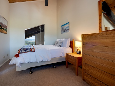 Drift off in this peaceful bedroom, where crisp white linens and warm wood touches create your perfect mountain escape. Rest easy under high ceilings as soft light filters through.
