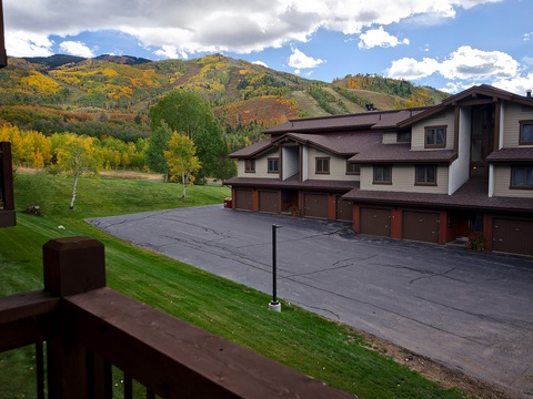 The property offers mountain-adjacent living with convenient parking and seasonal mountain views, surrounded by autumn aspen groves and rolling hills during the fall season.