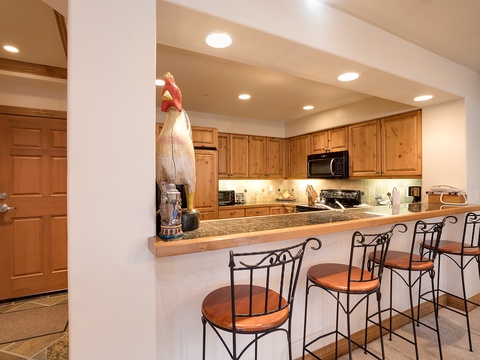 Gather around the breakfast bar in your fully equipped kitchen, complete with granite counters, modern appliances, and bar seating for four—a perfect space to prepare and share memorable meals together.
