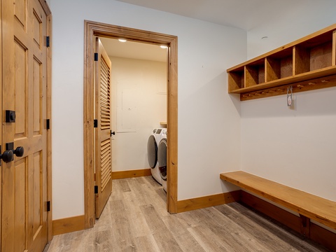 Your own organized mudroom awaits, with custom cubbies and bench space to stow gear after a day exploring, plus convenient laundry just beyond the louvered door.