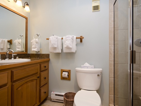 Your private bathroom features fresh towels, a spacious vanity, and a walk-in shower with modern fixtures—designed for comfort and convenience during your stay.