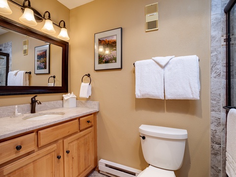Step into your private bathroom, featuring warm wood cabinetry, plush towels, and thoughtful touches. Fresh and inviting, it's your personal retreat after a day of adventure.