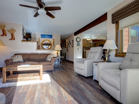 Picture yourself unwinding in this spacious, sun-filled living room with plush recliners and cozy western charm. The open layout flows into the kitchen, making your stay comfortable and inviting.