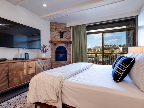 Unwind in your plush bedroom with a cozy fireplace, flat-screen TV, and stunning views through the private balcony—perfect for peaceful mornings and relaxing evenings.