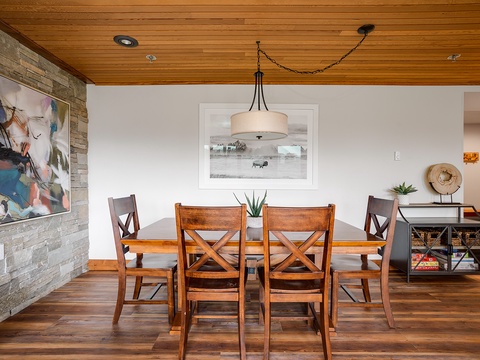 Gather around this warm, inviting dining space where wooden finishes and thoughtful artwork create the perfect backdrop for your shared meals and morning coffee conversations.