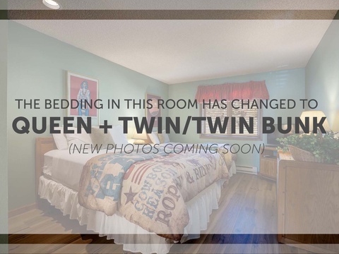 A bedroom with soft blue walls and cheerful artwork—your comfortable retreat with flexible sleeping arrangements for families or groups.