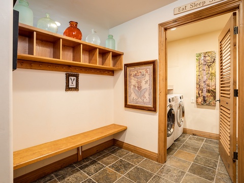 Step through your private entrance into a welcoming mudroom with custom shelving and a bench, leading to your dedicated laundry room with full-size washer and dryer—no need to leave the comfort of your stay.
