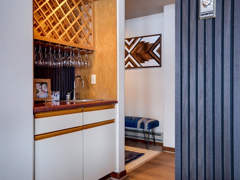 Step into your welcoming entryway, featuring a stylish wet bar with wine glass storage and sleek cabinetry—perfect for your first toast of the day.