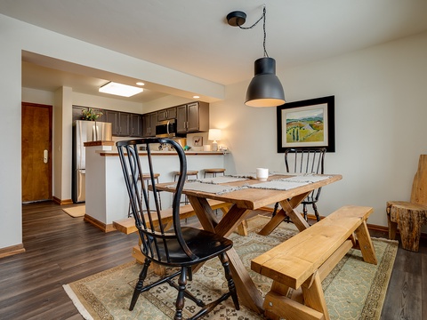 Gather around this handcrafted dining table where your morning coffee and shared meals feel warm and inviting. The open layout connects you to the fully equipped kitchen, making every moment together effortless.
