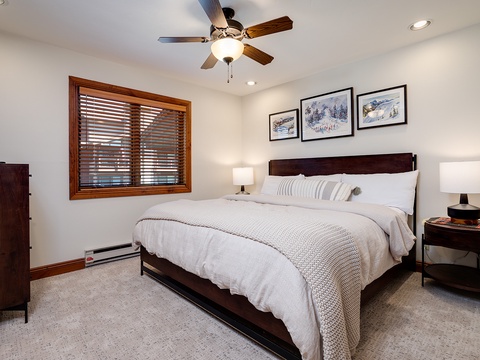Sink into plush linens and unwind in your serene bedroom, where soft lighting and mountain-inspired artwork set the mood for a restful escape after a day of adventure.